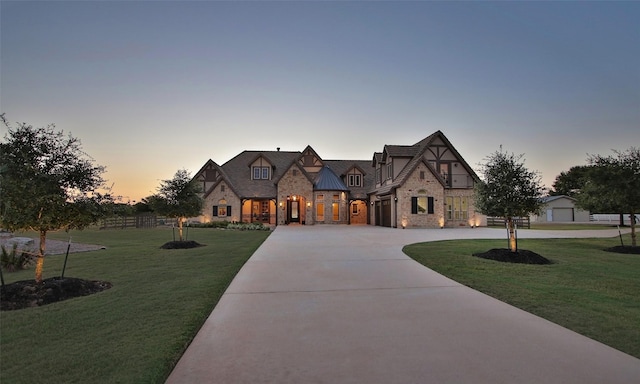 624 High Meadow Ranch Dr, Magnolia, TX 77355 - tudor-style house featuring stone siding, a front yard, and curved driveway