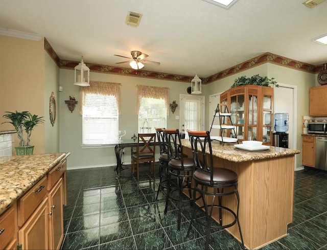 4915 Dove Springs Dr, Houston, TX 77066 - kitchen featuring appliances with stainless steel finishes, a breakfast bar area, ceiling fan, and light stone counters