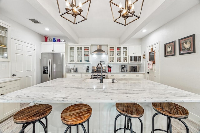 529 Fugate St, Houston, TX 77009 - kitchen featuring stainless steel appliances, a chandelier, wall chimney exhaust hood, a sink, and recessed lighting