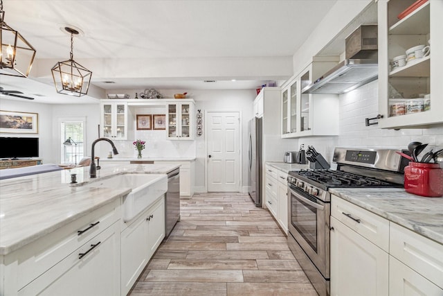 529 Fugate St, Houston, TX 77009 - kitchen featuring stainless steel appliances, a chandelier, a sink, backsplash, and light wood-type flooring