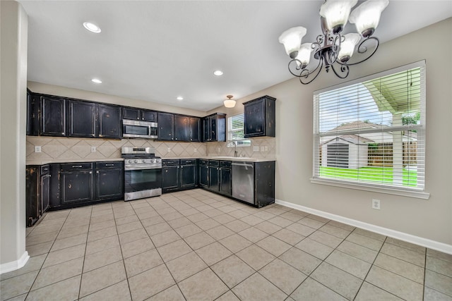 32126 Willow Creek Park, Conroe, TX 77385 - kitchen featuring appliances with stainless steel finishes, a chandelier, tasteful backsplash, light countertops, and light tile patterned floors