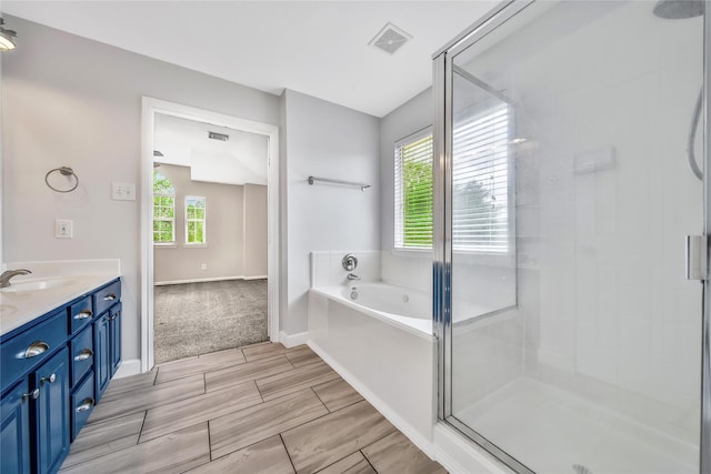 32126 Willow Creek Park, Conroe, TX 77385 - full bathroom featuring vanity, a shower stall, a garden tub, and wood tiled floors