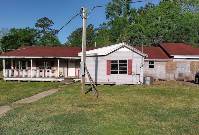 7730 Tram Rd, Beaumont, TX 77713 - view of front of property featuring a porch, a front yard, and central AC unit