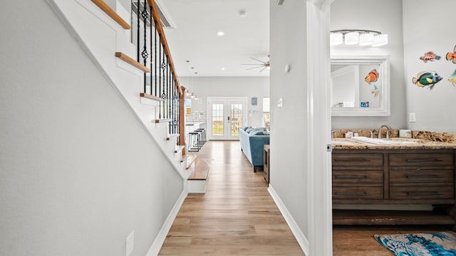 21530 San Luis Pass Rd, Galveston, TX 77554 - corridor featuring light wood-type flooring, stairs, a sink, baseboards, and recessed lighting