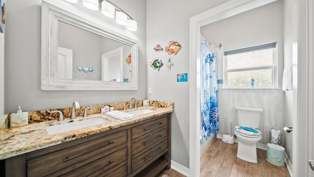 21530 San Luis Pass Rd, Galveston, TX 77554 - full bath with double vanity, toilet, wood finished floors, a shower with shower curtain, and baseboards
