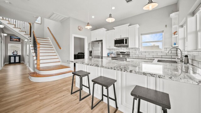 21530 San Luis Pass Rd, Galveston, TX 77554 - kitchen featuring stainless steel appliances, a sink, a peninsula, backsplash, and recessed lighting