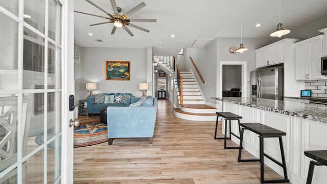 21530 San Luis Pass Rd, Galveston, TX 77554 - living area with stairs, light wood-style flooring, a ceiling fan, french doors, and recessed lighting