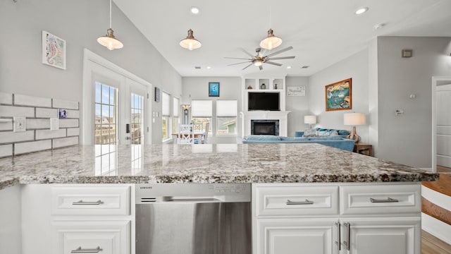 21530 San Luis Pass Rd, Galveston, TX 77554 - kitchen with dishwasher, ceiling fan, light stone countertops, a fireplace, and white cabinets