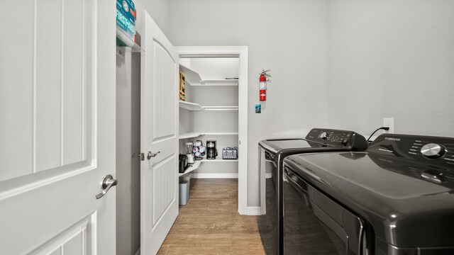 21530 San Luis Pass Rd, Galveston, TX 77554 - laundry room featuring washing machine and clothes dryer, light wood-style floors, and baseboards