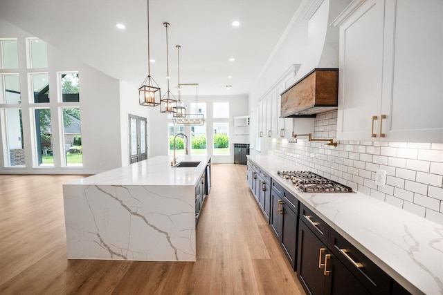 243 Teewood Ct, Montgomery, TX 77356 - kitchen featuring stainless steel gas stovetop, a sink, light wood-style floors, backsplash, and recessed lighting