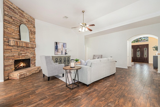 15814 Lake Loop Dr, Cypress, TX 77433 - living room with arched walkways, ceiling fan, dark wood finished floors, a stone fireplace, and ornamental molding