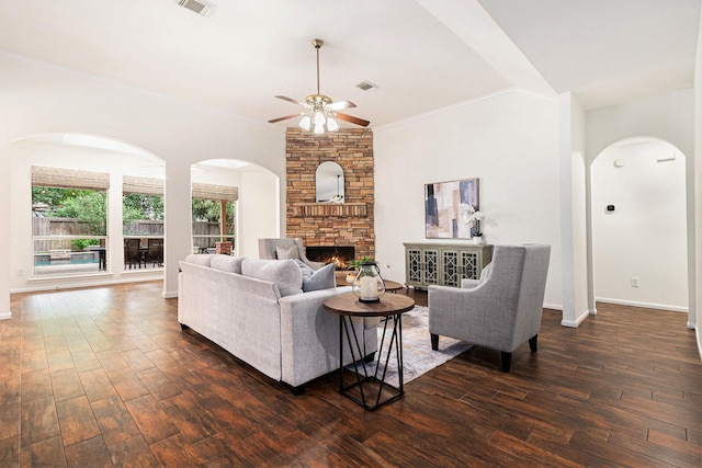 15814 Lake Loop Dr, Cypress, TX 77433 - living room featuring ceiling fan, dark wood-style flooring, arched walkways, crown molding, and a stone fireplace