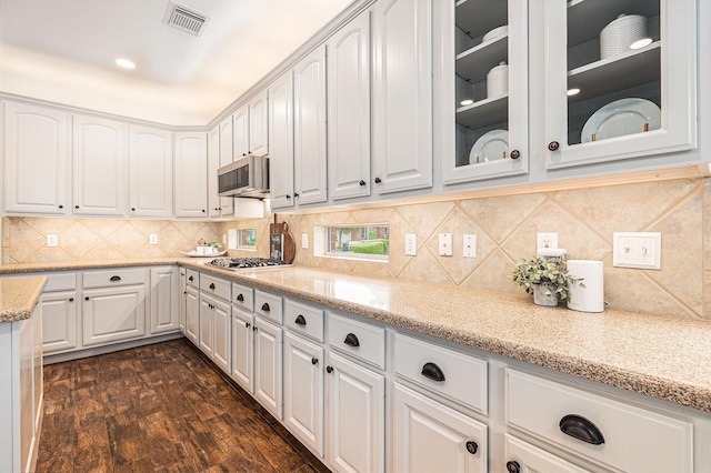 15814 Lake Loop Dr, Cypress, TX 77433 - kitchen with glass insert cabinets, white cabinets, light stone counters, and decorative backsplash