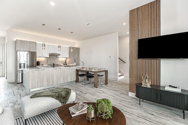 4024 Boho Ln, Houston, TX 77045 - living area featuring stairway, light wood finished floors, recessed lighting, and baseboards