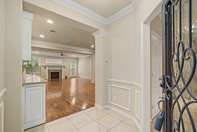 1121 Beall Landing Ct, Houston, TX 77008 - entrance foyer with a ceiling fan, light tile patterned floors, ornamental molding, a fireplace, and baseboards