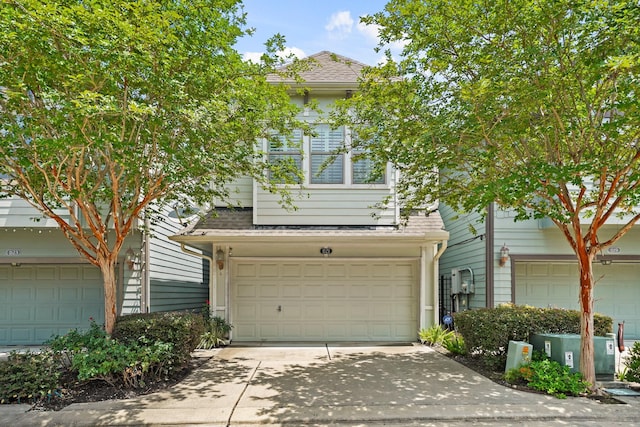 1121 Beall Landing Ct, Houston, TX 77008 - view of property hidden behind natural elements featuring a garage, a shingled roof, and concrete driveway