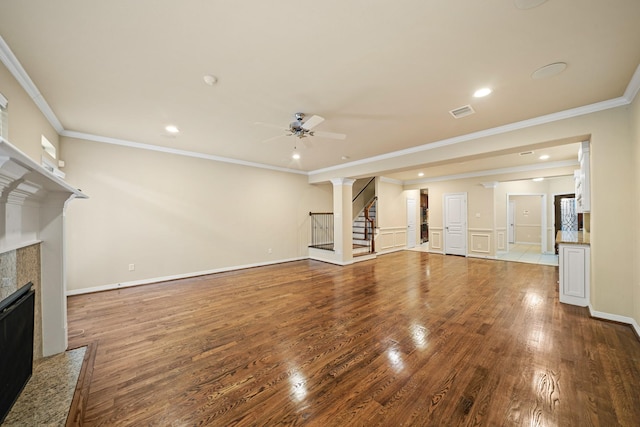 1121 Beall Landing Ct, Houston, TX 77008 - unfurnished living room featuring a fireplace, ceiling fan, stairs, wood finished floors, and ornamental molding