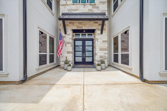 11011 Heartleaf Aster Way, Cypress, TX 77433 - entrance to property with french doors, stone siding, a standing seam roof, and stucco siding