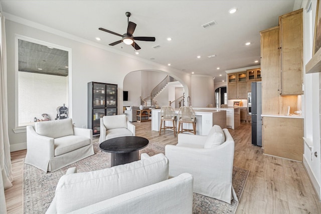 11011 Heartleaf Aster Way, Cypress, TX 77433 - living room with arched walkways, stairway, ceiling fan, recessed lighting, and light wood-style floors