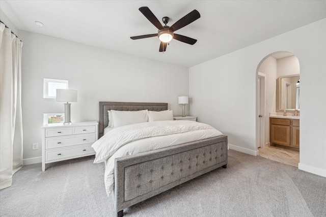 11011 Heartleaf Aster Way, Cypress, TX 77433 - bedroom featuring light carpet, arched walkways, baseboards, and ensuite bath