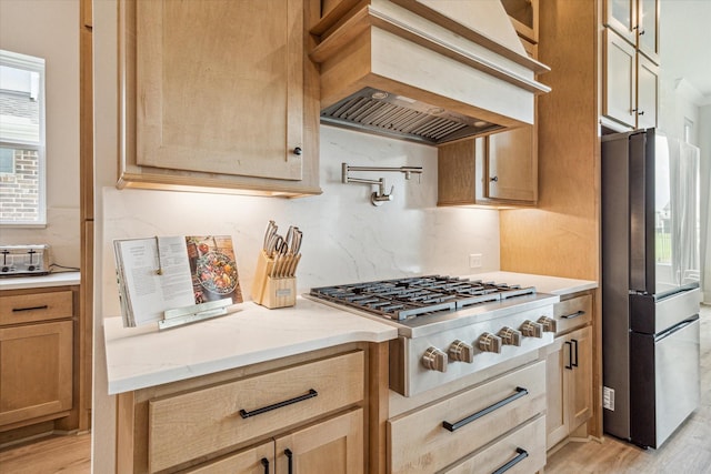 11011 Heartleaf Aster Way, Cypress, TX 77433 - kitchen featuring appliances with stainless steel finishes, custom exhaust hood, light wood-style floors, and tasteful backsplash