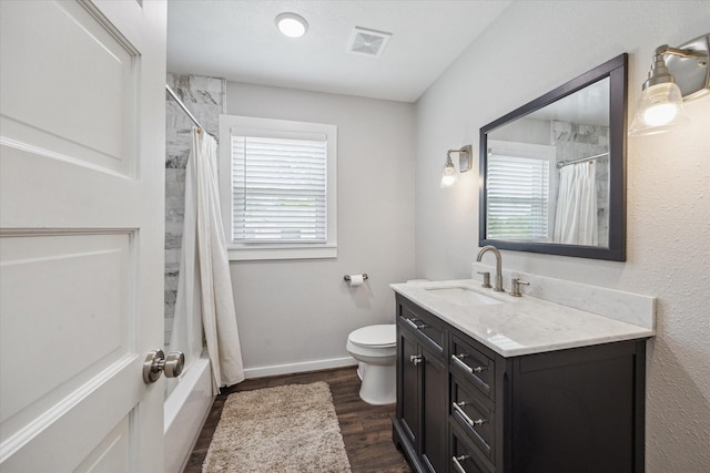 711 S Tesch St, Bellville, TX 77418 - bathroom featuring vanity, toilet, wood finished floors, shower / tub combo, and baseboards