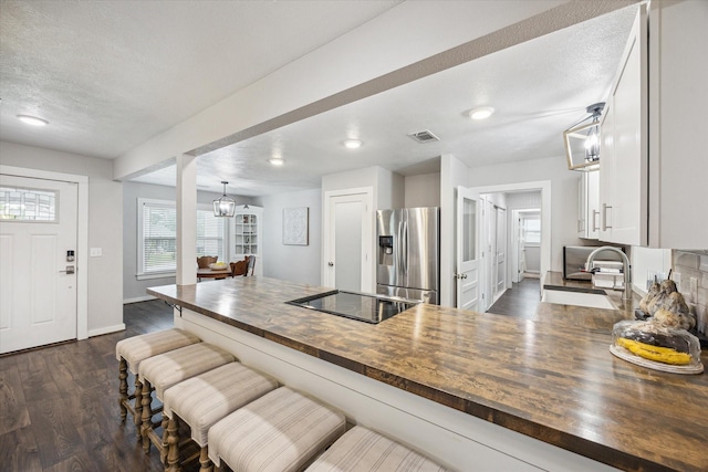 711 S Tesch St, Bellville, TX 77418 - kitchen featuring wood counters, stainless steel fridge, a sink, black electric stovetop, and baseboards