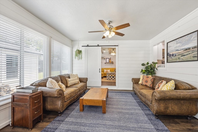711 S Tesch St, Bellville, TX 77418 - living area featuring a ceiling fan, wood finished floors, a barn door, and wood walls