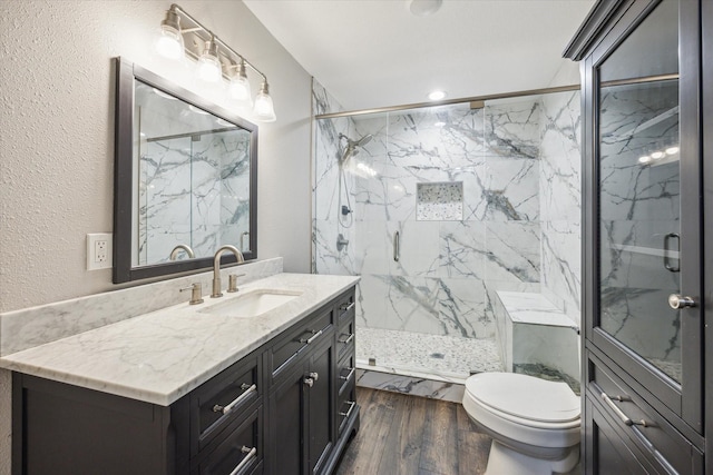 711 S Tesch St, Bellville, TX 77418 - bathroom featuring vanity, a marble finish shower, toilet, wood finished floors, and a textured wall