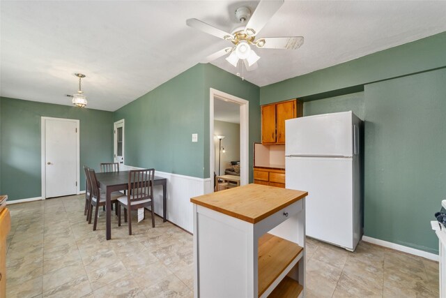 6601 Roos Rd, Houston, TX 77074 - kitchen featuring freestanding refrigerator, ceiling fan, butcher block counters, pendant lighting, and brown cabinetry