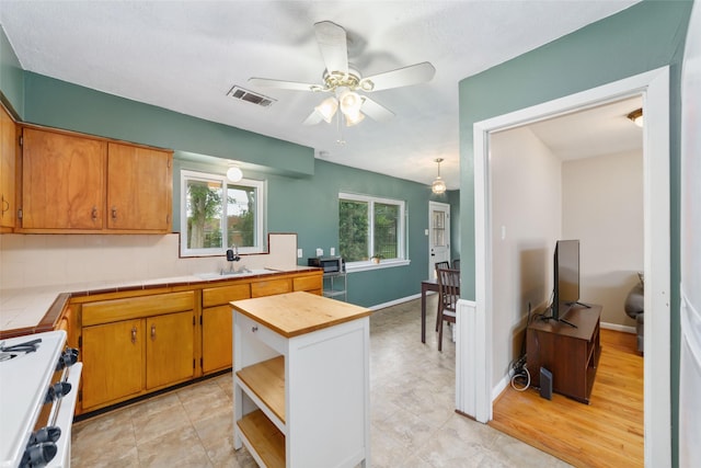 6601 Roos Rd, Houston, TX 77074 - kitchen featuring tile countertops, a ceiling fan, a sink, white range with gas cooktop, and open shelves