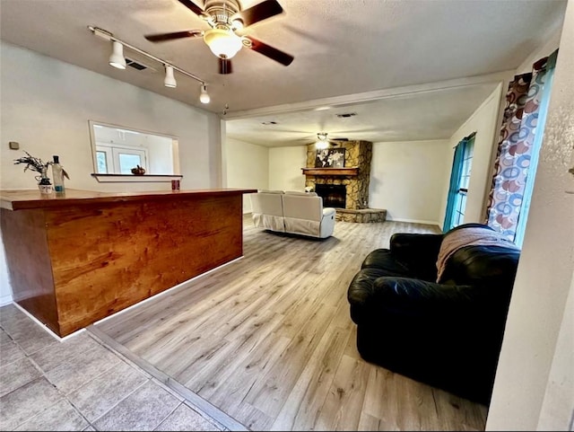 1008 Brockman St, Sweeny, TX 77480 - living room featuring a ceiling fan, a fireplace, wood finished floors, track lighting, and baseboards