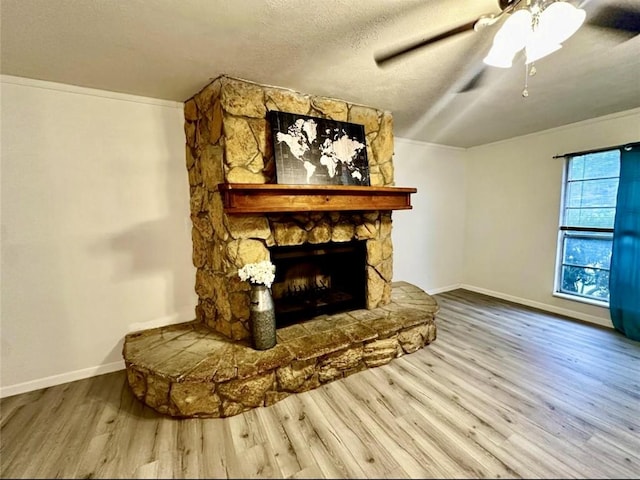 1008 Brockman St, Sweeny, TX 77480 - unfurnished living room with wood finished floors, baseboards, a ceiling fan, a fireplace, and a textured ceiling