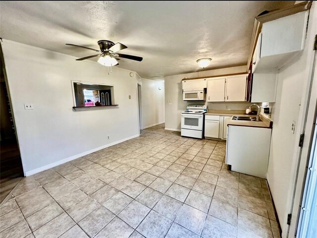 1008 Brockman St, Sweeny, TX 77480 - kitchen featuring white appliances, a sink, light tile patterned flooring, a ceiling fan, and white cabinetry