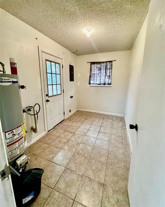 1008 Brockman St, Sweeny, TX 77480 - entrance foyer featuring a textured ceiling, light tile patterned flooring, water heater, and baseboards