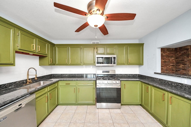6304 Crab Orchard Rd, Houston, TX 77057 - kitchen featuring stainless steel appliances, a sink, green cabinets, ceiling fan, and dark stone counters