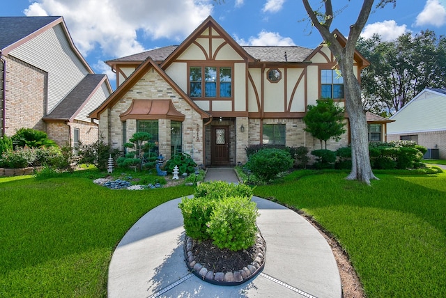 1610 Chapelwood Ln, Richmond, TX 77406 - tudor-style house featuring stucco siding, a front lawn, brick siding, and roof with shingles