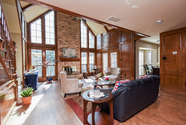1610 Chapelwood Ln, Richmond, TX 77406 - living room with a textured ceiling, wood finished floors, a fireplace, wood walls, and high vaulted ceiling