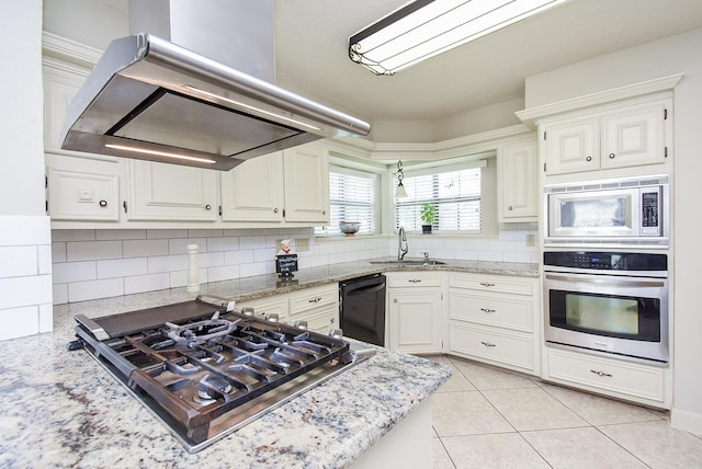 1610 Chapelwood Ln, Richmond, TX 77406 - kitchen featuring stainless steel appliances, island range hood, tasteful backsplash, light stone counters, and white cabinets
