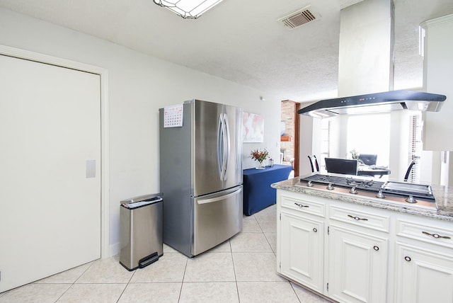 1610 Chapelwood Ln, Richmond, TX 77406 - kitchen featuring appliances with stainless steel finishes, wall chimney exhaust hood, light tile patterned floors, and white cabinetry