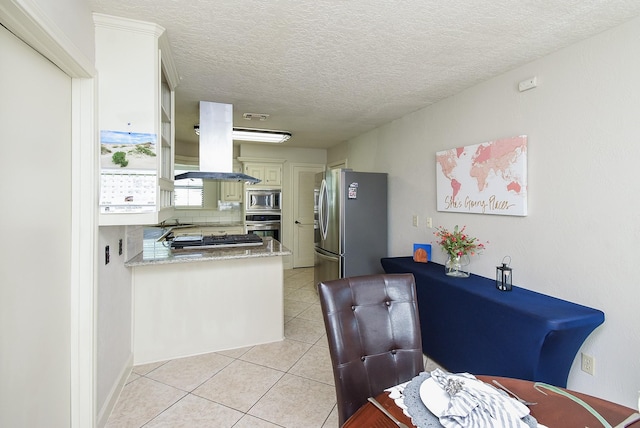 1610 Chapelwood Ln, Richmond, TX 77406 - kitchen with appliances with stainless steel finishes, light tile patterned flooring, a peninsula, a textured ceiling, and a sink
