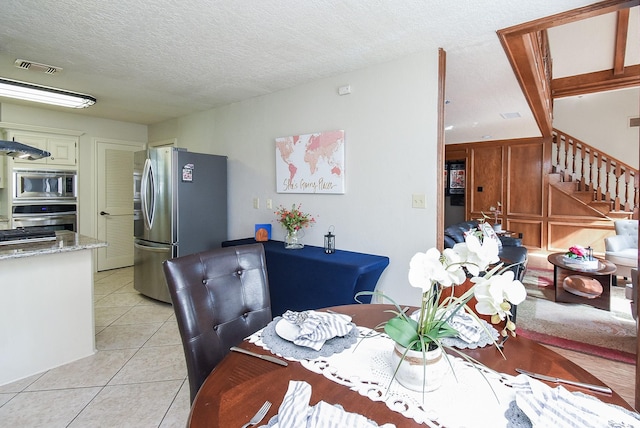 1610 Chapelwood Ln, Richmond, TX 77406 - dining space with stairway, light tile patterned floors, and a textured ceiling