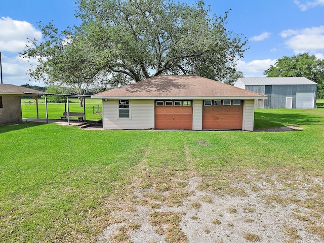 11221 State Highway 65, Winnie, TX 77665 - rear view of house with a garage, an outbuilding, and a yard