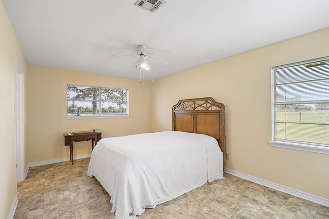 11221 State Highway 65, Winnie, TX 77665 - bedroom featuring multiple windows, baseboards, and a ceiling fan