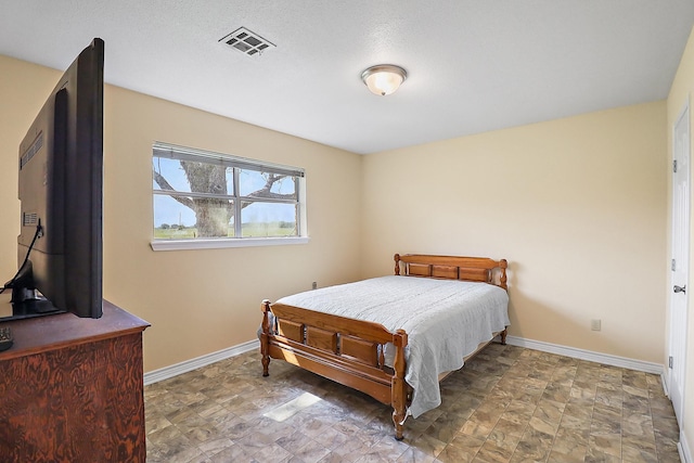 11221 State Highway 65, Winnie, TX 77665 - bedroom with baseboards and stone finish floors