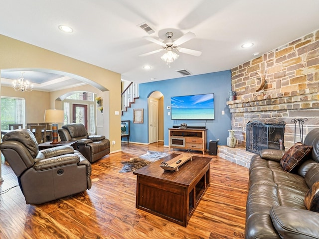 1003 Commons Waterway Dr, Huffman, TX 77336 - living room with arched walkways, wood finished floors, a chandelier, a fireplace, and a ceiling fan