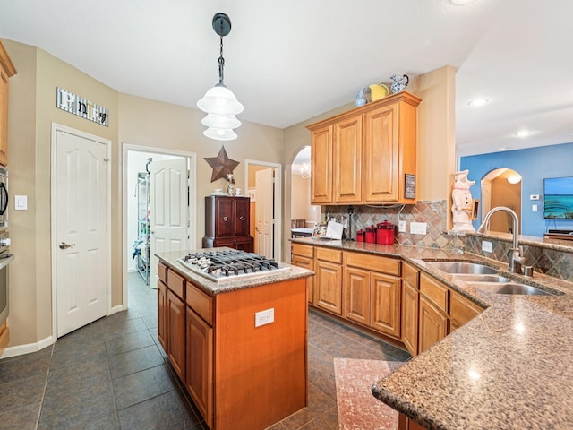 1003 Commons Waterway Dr, Huffman, TX 77336 - kitchen with gas stovetop, a sink, arched walkways, decorative backsplash, and hanging light fixtures