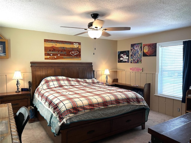 120 N 10th Ave, Teague, TX 75860 - carpeted bedroom with a textured ceiling, ceiling fan, and wainscoting