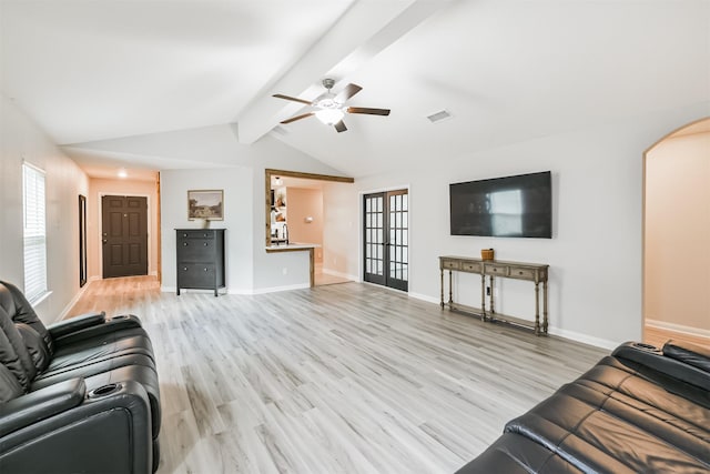 21100 Titian Dr, Magnolia, TX 77355 - living room featuring arched walkways, ceiling fan, light wood-style floors, and baseboards