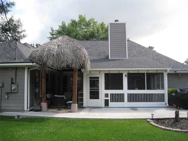 115 Texarkana Dr, Magnolia, TX 77354 - rear view of property featuring a patio area, a yard, a shingled roof, and a chimney